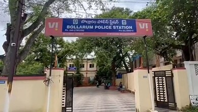Bollarum Police Station signboard in Secunderabad, India, with trees and buildings nearby.