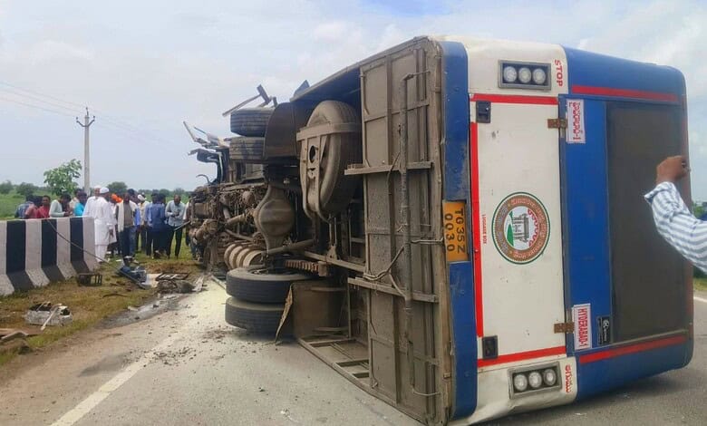 Bus overturned on roadside after accident near Kamareddy, with onlookers at the scene.