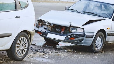 Damaged white car after a collision on the road in Hyderabad.