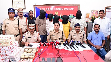 Police officers and suspects with seized cigarettes at Adilabad I-Town Police station.