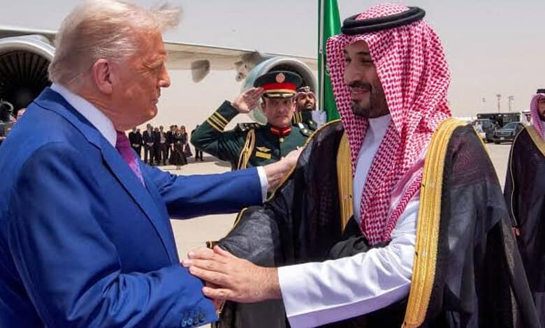 Donald Trump shaking hands with Saudi official during diplomatic visit, military personnel in background.