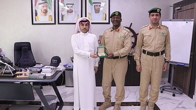 Saudi military officer receiving award from official in an office setting.