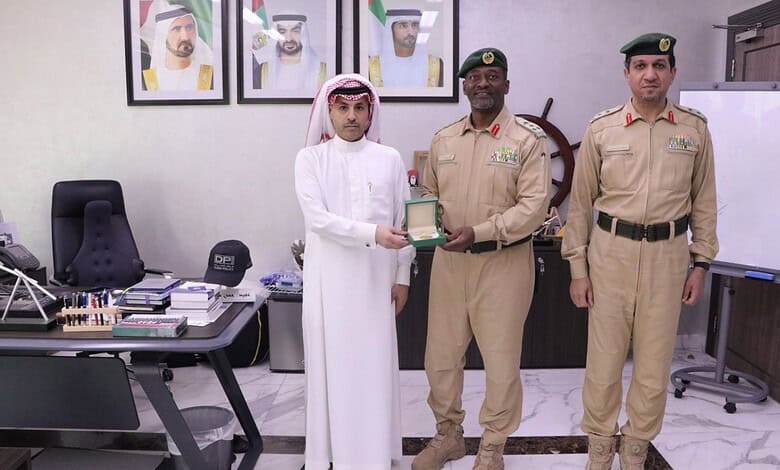 Saudi military officer receiving award from official in an office setting.