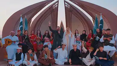 Group of people in traditional attire celebrating Saudi National Day with music and dance.
