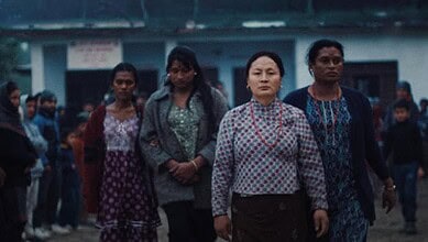 Group of women walking outdoors in a schoolyard or community area.