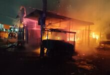 Nighttime fire at a building with flames and smoke, emergency response needed.