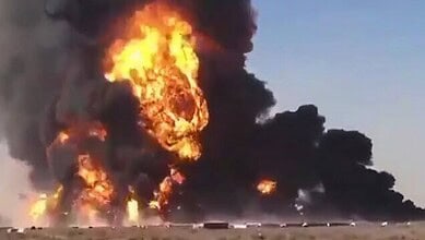 Massive fire with thick black smoke and bright flames in the sky.