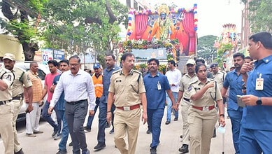 Police and officials monitor Ganesh immersion procession in Hyderabad with large crowd and decorated idol.