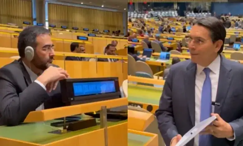 Israeli envoy and Iranian diplomat at UN meeting, engaging in discussion.