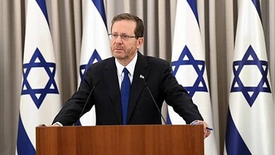 Israel President Isaac Herzog at podium.