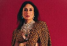 Kareena Kapoor wearing a leopard print dress with jewelry against a red background.