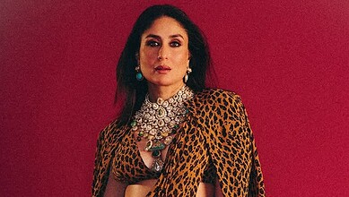 Kareena Kapoor wearing a leopard print dress with jewelry against a red background.