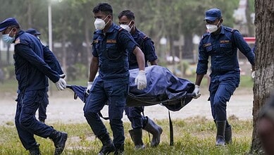 Rescue team members carry a body on a stretcher after Nepal floods.