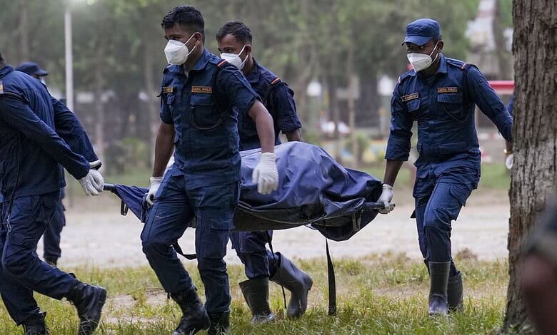 Rescue team members carry a body on a stretcher after Nepal floods.