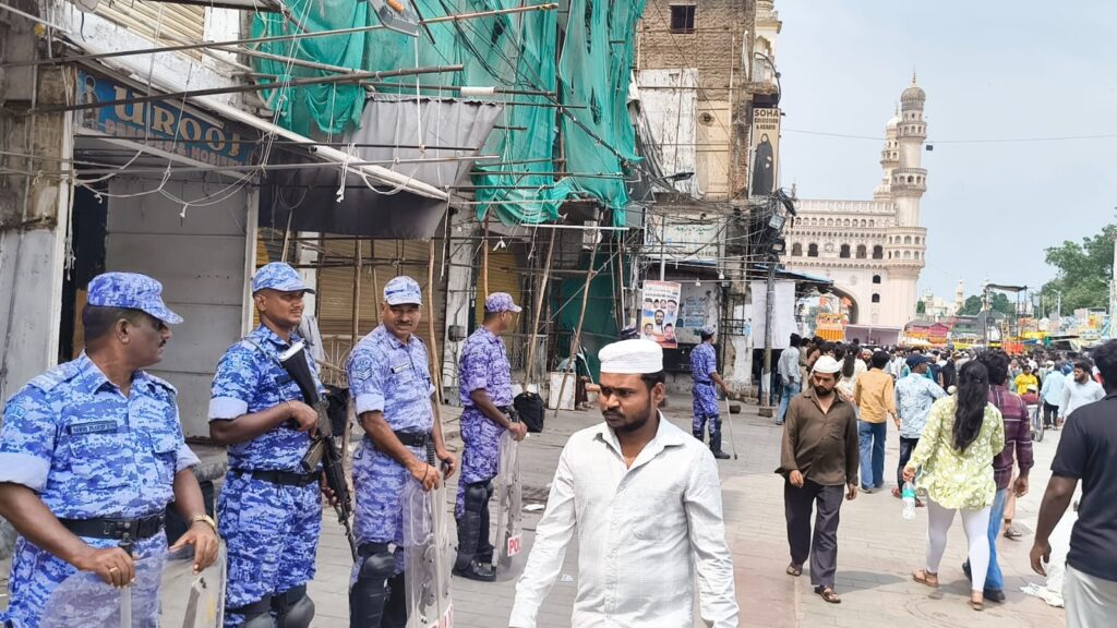 Security personnel in blue uniforms at Makkah Masjid during Friday prayers in Hyderabad.
