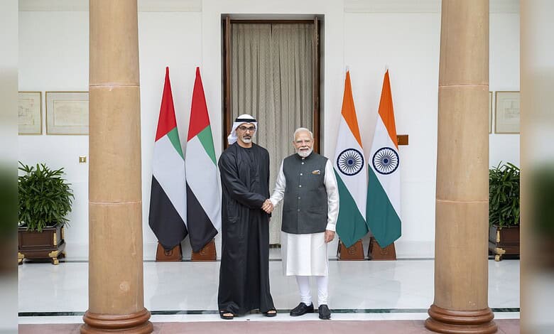 Modi and Sheikh Khaled shake hands at BRICS Summit with India and UAE flags behind them.