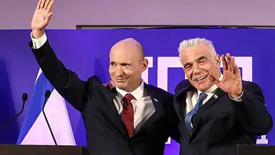 Israeli opposition leaders smiling and waving at a political event.