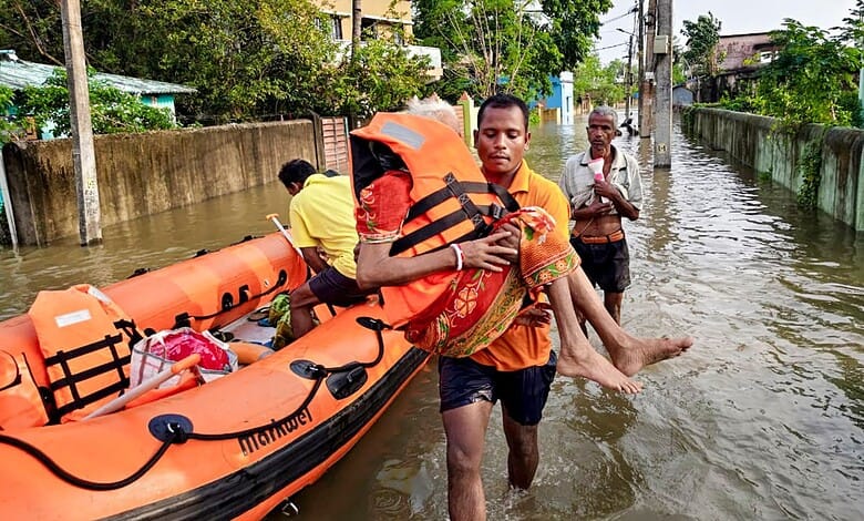 An official rescues flood-affected residents and moves them to a safer place following heavy rainfall, at Sahadevkhunta, in Baleswar district, Odisha, Saturday, Sept. 26, 2026. (PTI Photo)