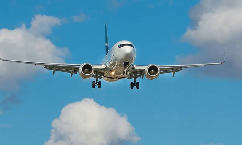 Passenger airplane approaching for landing with extended landing gear and open flaps.
