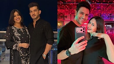 Couple taking a selfie at a vibrant indoor event, smiling and posing together.