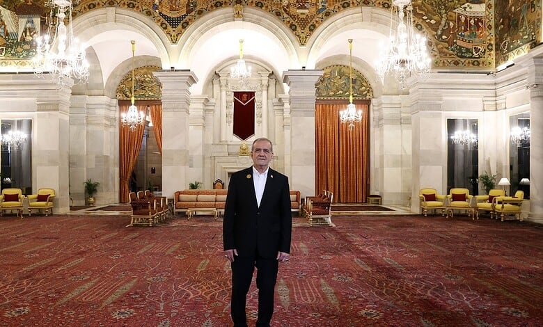 Pezeshkian standing in the grand hall of Rashtrapati Bhavan with ornate ceiling and chandeliers.