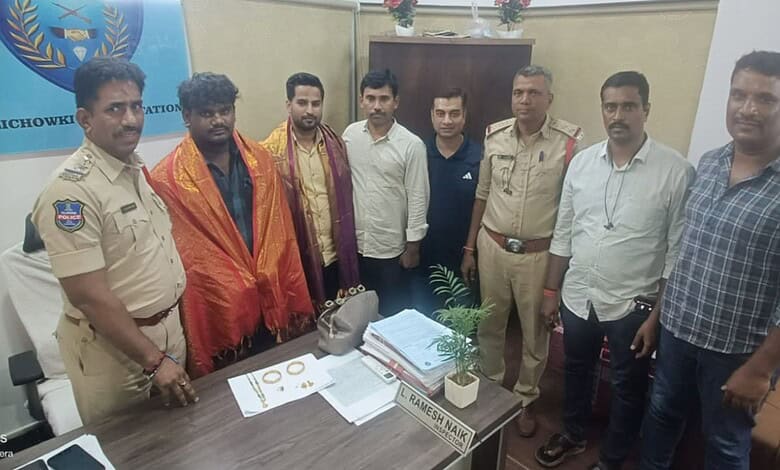 Group of men, including police officers, standing around a table with gold and cash in Hyderabad.