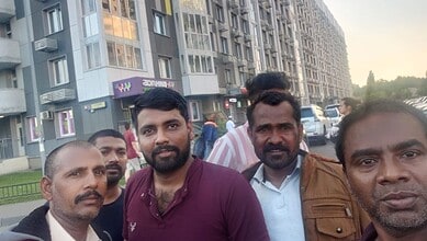 Group of Telangana residents on Russian battlefield, diverse men in urban setting.