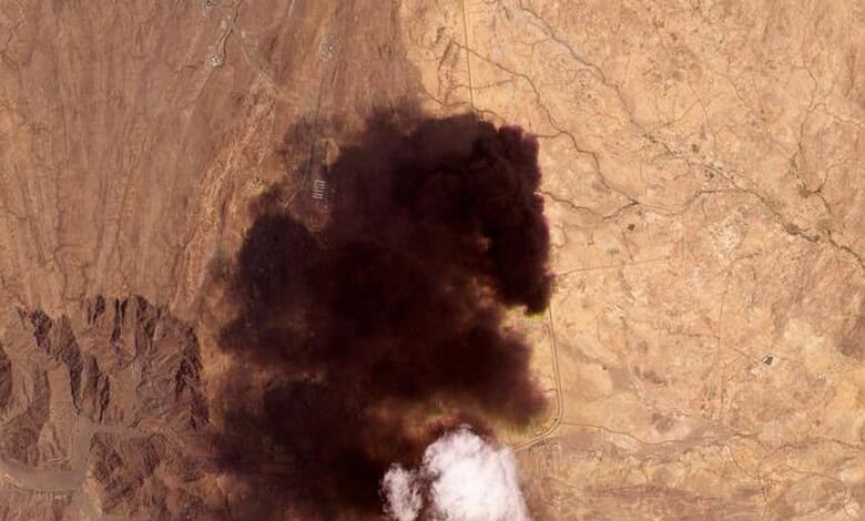 Large black smoke plume rising from a desert landscape after Houthi attack on Saudi Arabia.