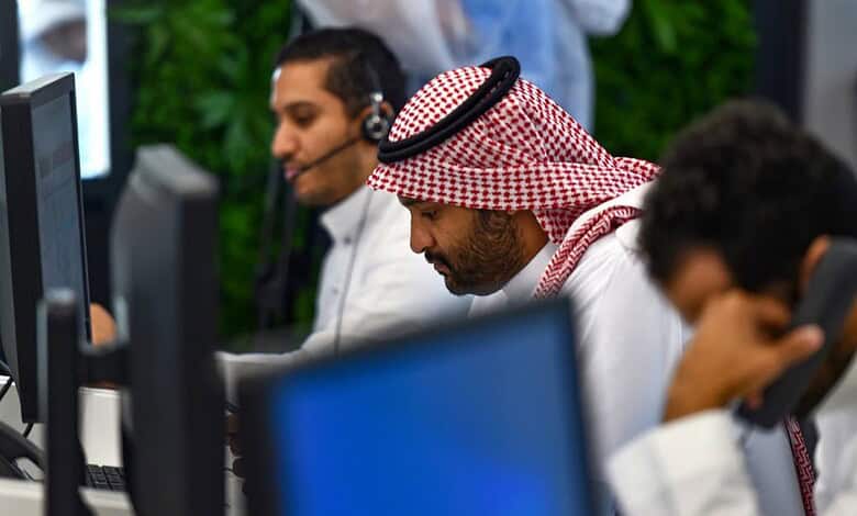 Saudi call center agents providing customer support with headsets and computers.