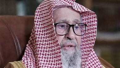 Saudi Grand Mufti in traditional attire, speaking seriously, urging resilience against Houthis.