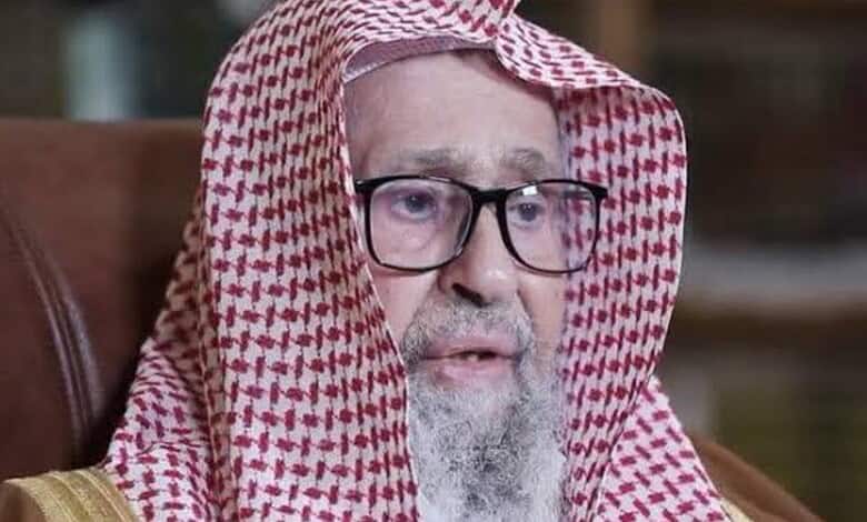 Saudi Grand Mufti in traditional attire, speaking seriously, urging resilience against Houthis.