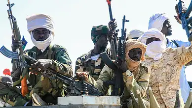 Militants in Darfur armed with rifles and dressed in traditional clothing and head coverings.