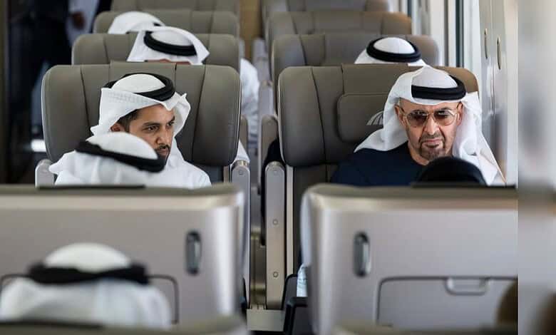 Men wearing traditional Emirati attire on a train in Dubai, attending the station opening.
