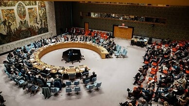 UN Security Council members seated in a large circular chamber during a meeting on Iran sanctions.