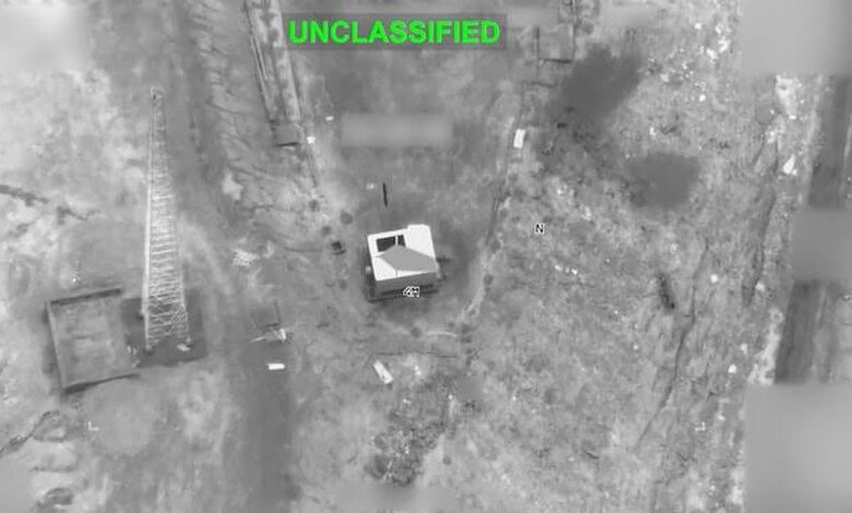 Aerial image showing a small building surrounded by open land and sparse vegetation.