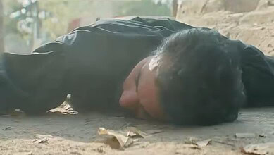 Pakistani man lying on the ground in a scene from a drama series.