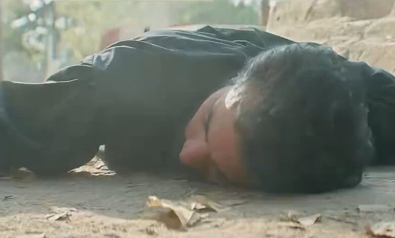 Pakistani man lying on the ground in a scene from a drama series.
