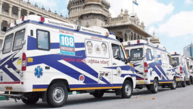 Three ambulances parked in front of a historic building in Karnataka, India.