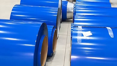 Rows of blue colour coated steel coils in a manufacturing facility.