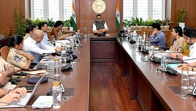 Officials and organizers discuss preparations for Bathukamma Festival in a formal meeting room.