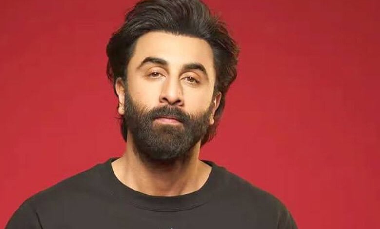 Portrait of a man with a beard and black hair against a red background.