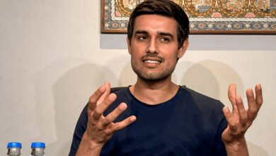 Dhruv Rathee speaking passionately with hand gestures in an indoor setting.