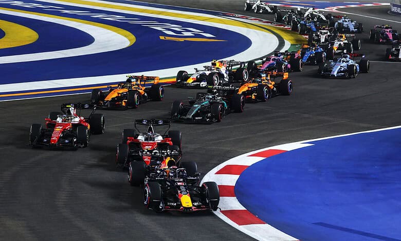 Formula 1 cars racing on the Singapore Grand Prix track during night race.