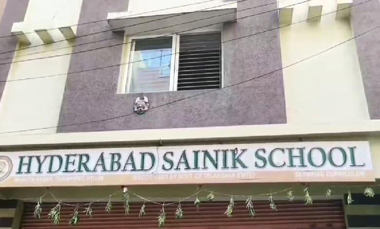 Hyderabad Sainik School building with school sign and decorative hanging ornaments.