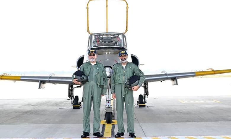 Indian Air Force pilots in green flight suits standing in front of a fighter jet at Hyderabad airbase.
