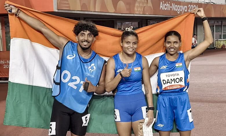 Indian athletes holding the Indian flag after winning medals at the Asian Para Games.