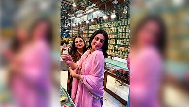 Isha Malviya shopping at a vibrant market in Hyderabad, wearing a pink traditional outfit.