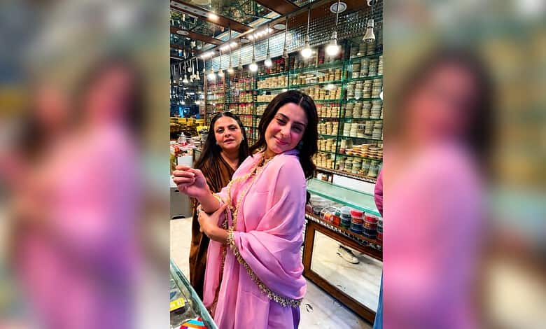 Isha Malviya shopping at a vibrant market in Hyderabad, wearing a pink traditional outfit.