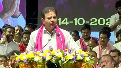 KTR speaking at a public event with a floral arrangement in front, surrounded by supporters.