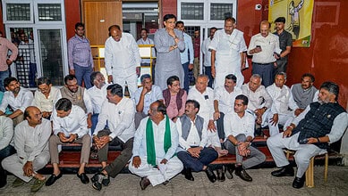 Karnataka Chief Minister DK Shivakumar, right, along with cabinet colleagues and party leaders stages a sit-in demonstration outside the office of Chief Electoral Officer V. Anbukkumar, in Bengalu